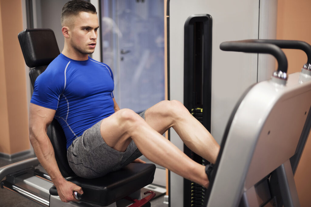 Homem realizando exercício leg press no treino de perna