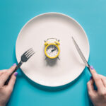 Prato com relógio representando o conceito de jejum intermitente e treino em jejum