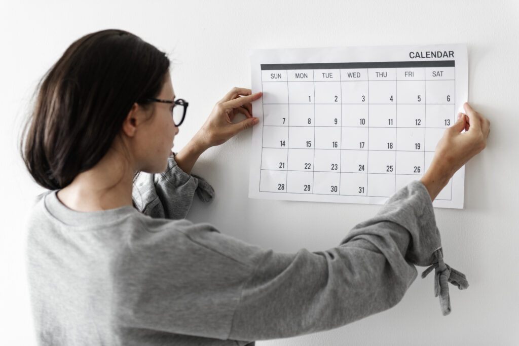 Mulher organizando calendário de treinos para manter frequência semanal