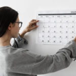 Mulher organizando calendário de treinos para manter frequência semanal
